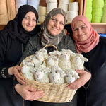 Bebemoss crochet artisans holding a basket of handmade, crochet sheep