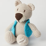 The MADE51 Peace Bear sat up, wearing a little light blue jacket and a Peace For All label on its foot