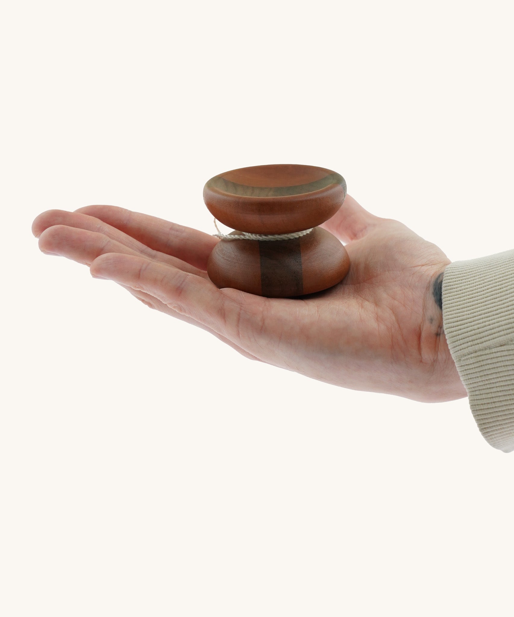 An adult hand holding the Mader free wheel butterfly yoyo available at Babipur showing scale