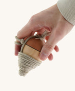an adult hand holding the Mader natural profi throw wooden spinning top available at Babipur showing scale