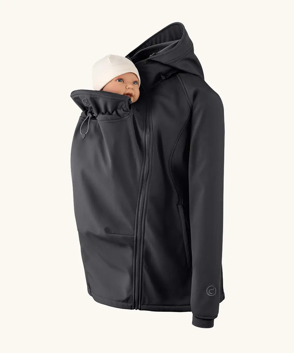 Mamalila soft shell baby wearing allrounder fitted jacket in black showing baby doll demonstrating the forward sitting position 
