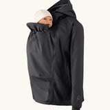 Mamalila soft shell baby wearing allrounder fitted jacket in black showing baby doll demonstrating the forward sitting position 