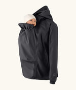 Mamalila soft shell baby wearing allrounder fitted jacket in black showing baby doll demonstrating the forward sitting position 