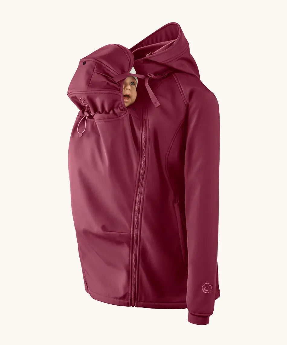 Mamalila soft shell baby wearing allrounder fitted jacket in burgundy showing a baby doll with the protective hood covering the head