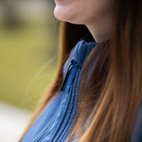 A close up of a mother wearing the Mamalila soft shell baby wearing allrounder fitted jacket in navy available at Babipur showing the zip detail