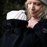 Close up of Mamalila soft shell baby wearing allrounder fitted jacket in black showing the toggle on the back of the hood