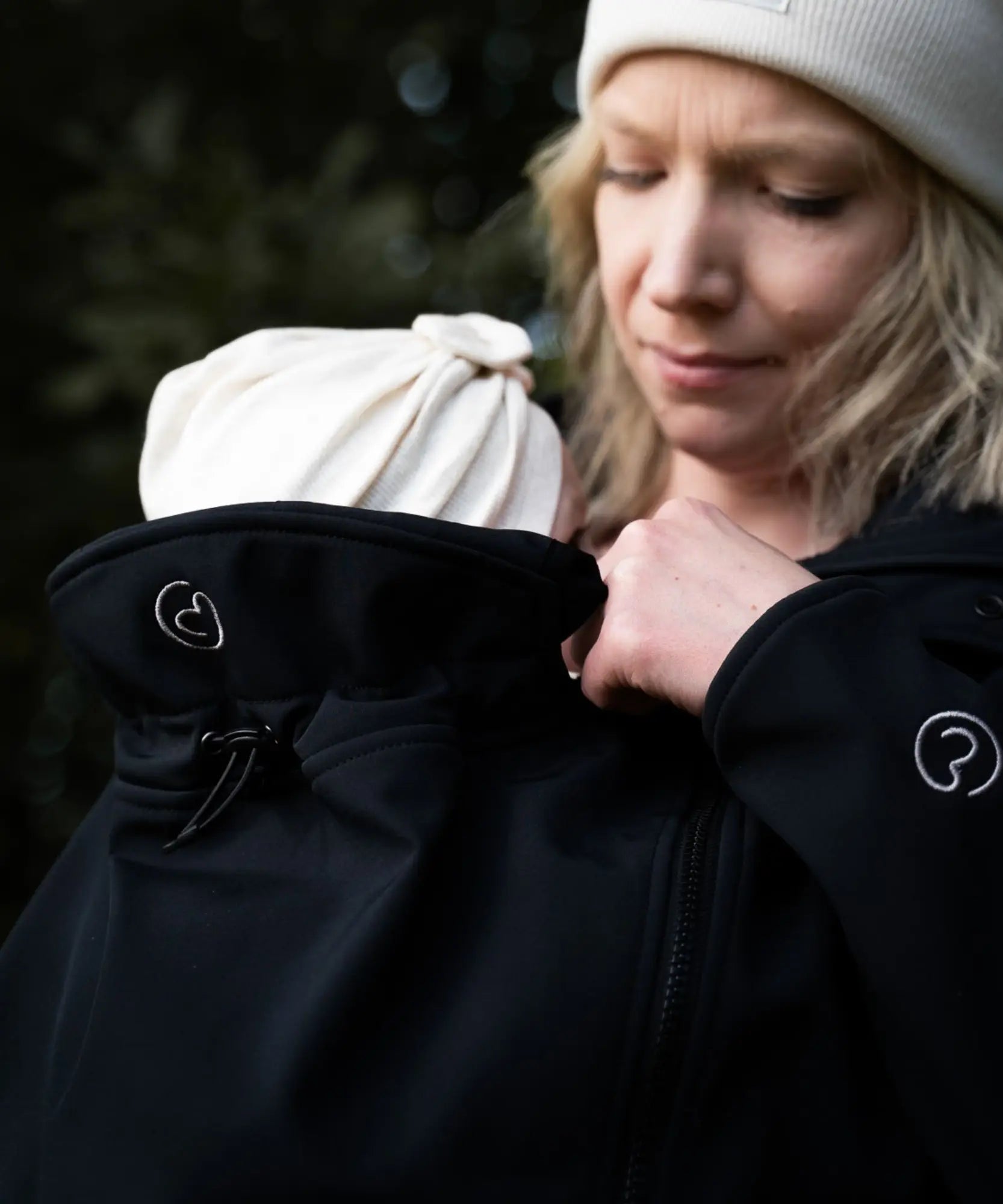 Close up of Mamalila soft shell baby wearing allrounder fitted jacket in black showing the toggle on the back of the hood