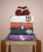 Stack of Maxomorra kids long sleeve tops with Little Green Radicals knitted booties on top.