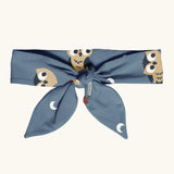 Maxomorra kids GOTS organic cotton hairband in blue with a repeating cute owl print. Hairband is in a knot tie style 