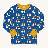 Maxomorra Rainbow Long Sleeved Children's Top is blue with a repeat rainbow print, and contrasting yellow elasticated cuffs and neck trim 