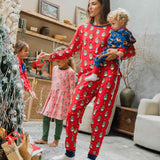 A woman wearing a Maxomorra Swedish Santa Adult Long Sleeve Pyjama Set holding a small child that is wearing a reindeer print rompersuit. 