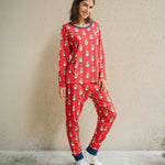 A woman wearing a Maxomorra Swedish Santa Adult Long Sleeve Pyjama Set standing in front of a beige coloured wall.