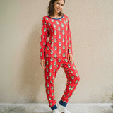 A woman wearing a Maxomorra Swedish Santa Adult Long Sleeve Pyjama Set standing in front of a beige coloured wall.