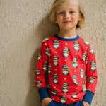 A child wearing a Maxomorra Swedish Santa Long Sleeve top. The child is stood in front of a beige coloured wall.