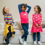 Three children wearing Maxomorra, the first is wearing stripes, the child in the middle is wearing a unicorn raglan top and the third child is wearing the Maxomorra Unicorn Long Sleeve Circle Dress.