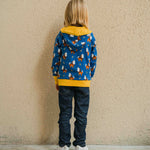A child wearing a Maxomorra Wolf Reversible Zip Hoodie. The child is facing away from the camera showing the back of the hoodie. 