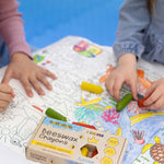 A closeup of children using the Medenka natural beeswax crayons to colour in an ocean drawing. 
