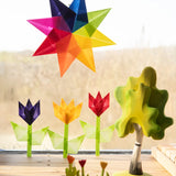 Window display using coloured waxed paper showing different coloured flowers and a rainbow star