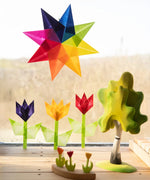 Window display using coloured waxed paper showing different coloured flowers and a rainbow star