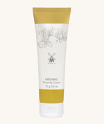 MÜHLE Organic Shaving Cream in a mustard and white tube with delicate olive branch design on the packaging and the Muhle logo in the middle. On a cream background