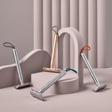 A collection of four MÜHLE Companion Safety Razors on a light pink display and background