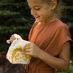 A child looking into the Namaki Gold Fox Sparkling Pouch