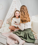 Two children sitting in a bedrom putting on eye shadow from the Namaki Natural Eyeshadow Pallet