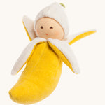 Nanchen Banana Rattle Doll. A beautifully handmade rattle toy in the shape of a banana, perfect for little hands to grasp. The rattle has 4 peeled banana parts and a cute little doll head at the top. On a cream background