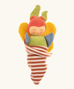 Nanchen soft butterfly doll in a brown striped blanket. Features a green body, blue arms, yellow wings and a red hat.
