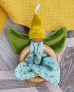 Nanchen organic cotton flower fairy baby toy featuring wooden grasping ring, soft green velour wings, yellow pointed hat, and loops for hanging, sold at Babipur.