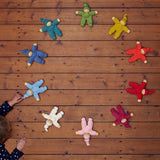 The Nanchen Waldorf Pimpel dolls in a circle, with a child playing with a light blue on in the bottom left hand corner