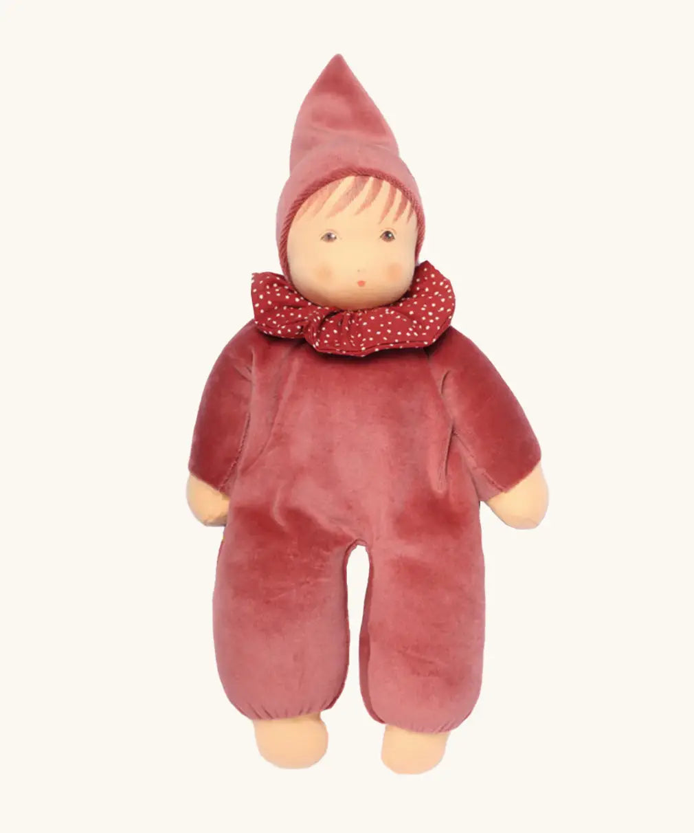 Nanchen nani soft doll in cedar pink with a waldorf style face. Showing a red with white spots frilled scarf and red hat