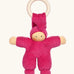 Nanchen Pimpel Doll Baby Comforter in berry pink with a Waldorf-style face and wooden teething ring attached by its hat. 