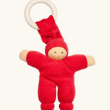 Nanchen Pimpel Doll Baby Comforter in cherry red with a Waldorf-style face and wooden teething ring attached by its hat. 
