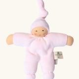 Nanchel pimpel waldorf doll in pastel pink. Showing cute facial features and a tie on the hat. Doll has a terry cloth body 