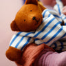 A beautifully handmade teddy bear comforter toy, the Nanchen Baby Comforter - Bear has brown face and  hands, and a blue and white stripe body