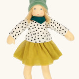 Nanchen Mascha waldorf doll showing a green terry cloth, long sleeve top with black dots, a yellow skirt and a green scarf