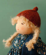 Nanchen winterchild lotta doll showing close up of the Waldorf style face and knitted orange hat