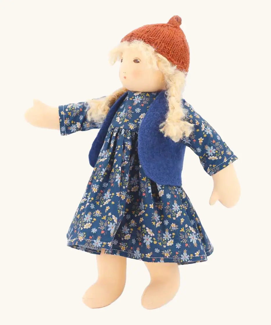 Nanchen Lotta winterchild doll with a Waldorf style face, blonde hair. Showing removable blue waistcoat, navy floral dress and orange hat