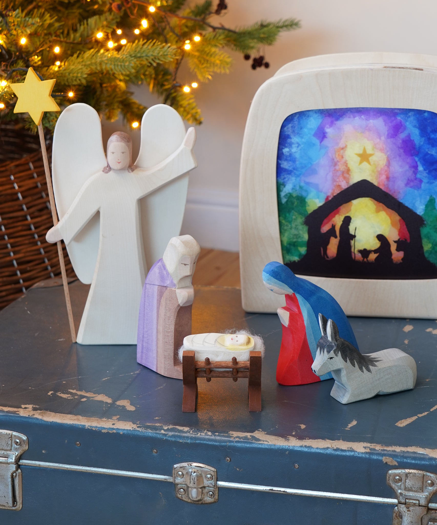 Nativity Christmas scene featuring wooden toy figures from Ostheimer - Donkey II, Angel with Star, Mary, Joseph  and Baby Jesus in Crib II - available to buy at Babipur.

