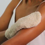 A person using the Green People Exfoliating Mitt on their arm