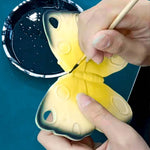 A close up of the Oli & Carol Natural Rubber Teether - Katia The Butterfly having its details painted on
