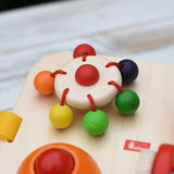 Close up of the carouserl rattle top attached to the Nic Wooden Baby Game busy Board with 4 four activities.