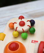 Close up of the carouserl rattle top attached to the Nic Wooden Baby Game busy Board with 4 four activities.