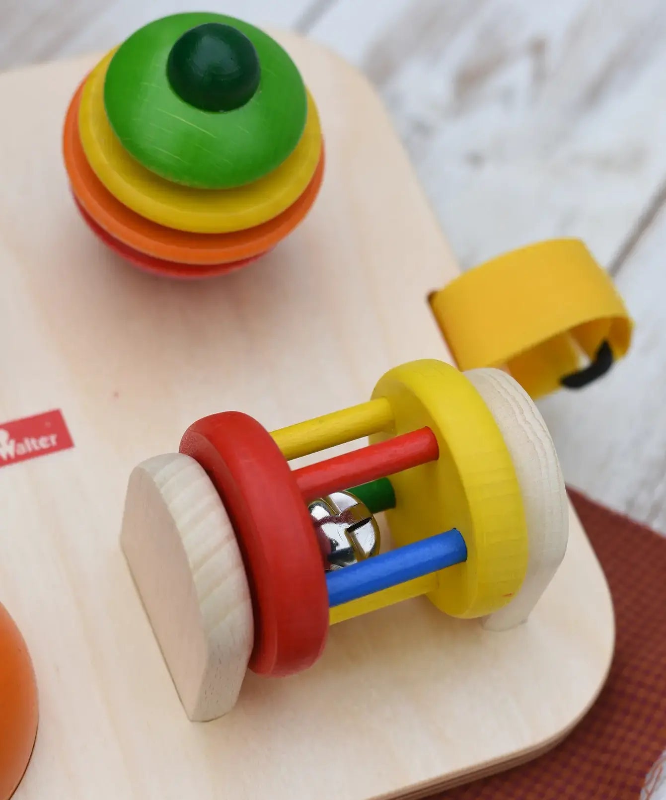 Close up of the rattling tree top and roller attached to the Nic Wooden Baby Game busy Board with 4 four activities.