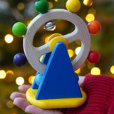 Baby wooden sensory toy, Nic Ferris Wheel, a chunky bright blue stand holding a rotating wheel dotted with rainbow coloured beads and bells, for sale at Babipur.