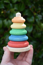 Nic Classic Stacking Tower wooden baby toy in an adult's hand.
