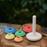 Nic Classic Stacking Tower placed on a wooden board with the rainbow rings taken off the base pole.