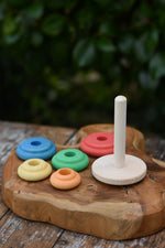Nic Classic Stacking Tower placed on a wooden board with the rainbow rings taken off the base pole.