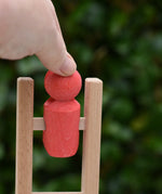 Close up of the Nic climbing wooden ladder toy with a small red peg person being placed on the top ring.